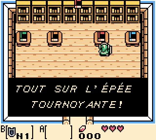 Une capture d’écran du jeu, avec un dialogue « TOUT SUR L’ÉPÉE TOURNOYANTE » avec deux accent sur les E de épée.